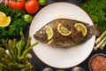 Eastern or European cuisine, Fried fish with fresh vegetables, on a wooden black background. I also eat healthy food. Seafood, Royalty Free Stock Photo