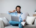 Eastern Freelancer Man With Cellphone, Papers And Laptop Working Remotely At Home Royalty Free Stock Photo