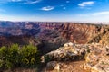 Eastern Grand Canyon at sunset. Rocks and trees in foreground; canyon walls and Colorado river in background. Royalty Free Stock Photo