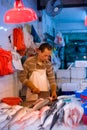 A fishmonger at a fresh fish shop on the markets of Chun Yeung Street in North Point district at Hong Kong