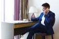 Eastern man in suit working in hotel, talking by phone