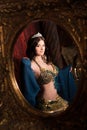 Eastern princess with crown. Attractive, sensual woman in luxury palace