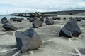 Large boulders on tarmac in front of a huge storm surge barrier Royalty Free Stock Photo