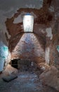 An abandoned decaying cell with furniture and a single glass skylight in prison.