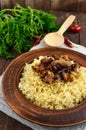 Eastern traditional wheat porridge - bulgur with roasted pieces fatty meats, bacon in a clay bowl