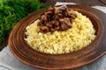 Eastern traditional wheat porridge - bulgur with roasted pieces fatty meats, bacon in a clay bowl