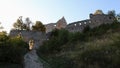 Eastern walls and main entrance to ruins of early gothic castle Topolcany during early fall sunset.