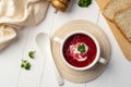 Easy beetroot soup with sour cream,creamy soup in a white bowl.