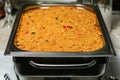 Easy bulgur pilaf pilavi with tomatoes in a ceramic bowl on a dark background close-up. Turkish cuisine, vegan food. Royalty Free Stock Photo