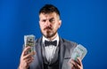 Easy cash loans. Man formal suit hold pile of dollar banknotes blue background. Businessman got cash money. Richness and Royalty Free Stock Photo