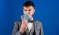 Easy cash loans. Man formal suit hold pile of dollar banknotes blue background. Businessman got cash money. Richness and Royalty Free Stock Photo