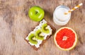 Easy diet breakfast. Sandwich with cottage cheese and slices of kiwi, grapefruit and homemade yogurt