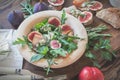 Easy diet salad with arugula, figs and blue cheese on a brown wooden surface. Sandwiches with ricotta, fresh