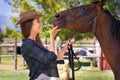 Easy girl. a young cowgirl standing outside with her horse. Royalty Free Stock Photo