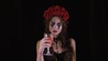 Easy Halloween Makeup. The girl with the picture on her face. The devil`s bride with a wreath of red flowers on her head. Woman Royalty Free Stock Photo