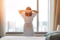 Easy lifestyle Asian woman waking up from good sleep in weekend morning taking some rest, relaxing in comfort bedroom at hotel Royalty Free Stock Photo