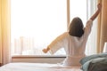 Easy lifestyle Asian woman waking up from good sleep in weekend morning taking some rest, relaxing in comfort bedroom at hotel Royalty Free Stock Photo