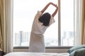 Easy lifestyle Asian woman waking up in weekend morning taking some rest relaxing in comfort city hotel room Royalty Free Stock Photo