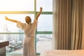 Easy lifestyle Asian woman waking up in weekend morning taking some rest relaxing in comfort city hotel room Royalty Free Stock Photo