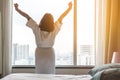 Easy lifestyle Asian woman waking up in weekend morning taking some rest relaxing in comfort city hotel room enjoying world lazy Royalty Free Stock Photo