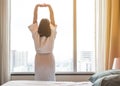 Easy lifestyle Asian woman waking up in weekend morning taking some rest relaxing in comfort city hotel room enjoying world lazy Royalty Free Stock Photo