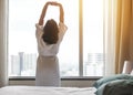 Easy lifestyle Asian woman waking up in weekend morning taking some rest relaxing in comfort city hotel room enjoying world lazy Royalty Free Stock Photo