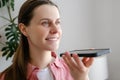 Easy mobile ai technology concept. Close up of smiling young woman holding phone speak activate virtual digital voice assistant on Royalty Free Stock Photo