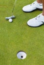 The easy ones take a lot of concentrating. High angle cropped shot of a golfer about to putt a ball in the hole. Royalty Free Stock Photo