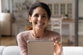 Portrait of motivated latin woman sit on sofa hold pad Royalty Free Stock Photo