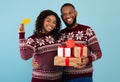 Easy and quick gifts for Christmas with online shopping. Happy african american couple holding gifts and credit card Royalty Free Stock Photo