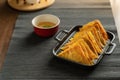 Easy recipe, snacks, minced pork meat filled fried wontons sort in black dish on grey placemat, brown wood table served with sweet Royalty Free Stock Photo