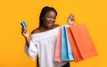 Easy Shopping. Joyful Black Lady Holding Credit Card And Bright Shopper Bags