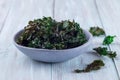 Easy three ingredient baked green kale chips with sea salt and olive oil, in gray bowl, horizontal