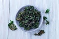 Easy three ingredient baked green kale chips with sea salt and olive oil, in gray bowl, horizontal, top view