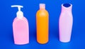 Easy to refill and dispense. Toiletry bottles in row. Refillable bottles blue background