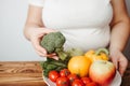 Fat woman snacking with fruits and vegetables Royalty Free Stock Photo