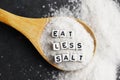 Eat less salt advice written with plastic letter beads on granulated salt Ã¢â¬â healthy food lifestyle