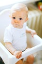 Eat smeared baby in chair impressively looking Royalty Free Stock Photo