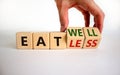 Eat well or eat less symbol. Businessman turns cubes and changes words `eat less` to `eat well`. Beautiful white background.