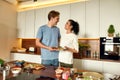 Eat Well. Happy couple, vegetarians cooking breakfast in the kitchen together. Young man and woman preparing healthy