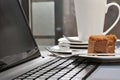 Eaten cake on laptop beside stack of dirty plates on desk Royalty Free Stock Photo