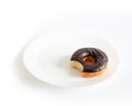 Eaten chocolate donut isolated on white background. doughnut has been bitten on plate Royalty Free Stock Photo