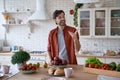 Eating apple every morning. Young happy bearded man in casual clothes throwing up a red apple and smiling while standing Royalty Free Stock Photo