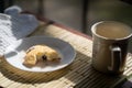 Eating a blueberry scone and cup of hot drink.