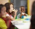 Eating, boy and children class for lunch at school or creche for an education or to learn. Break, kid and sandwich in a Royalty Free Stock Photo