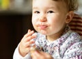 Eating cheerful baby girl with messy face Royalty Free Stock Photo