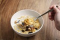Eating corn flakes with fruits and nuts in white bowl Royalty Free Stock Photo