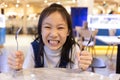 Eating disorder,Asian cute girl hungry waiting for lunch and order in the restaurant,Holding for a spoon and fork,hangry Royalty Free Stock Photo