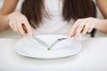 Eating disorder. Girl is holding a plate and trying to put a pea Royalty Free Stock Photo