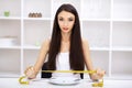 Eating disorder. Girl is holding a plate and trying to put a pea Royalty Free Stock Photo